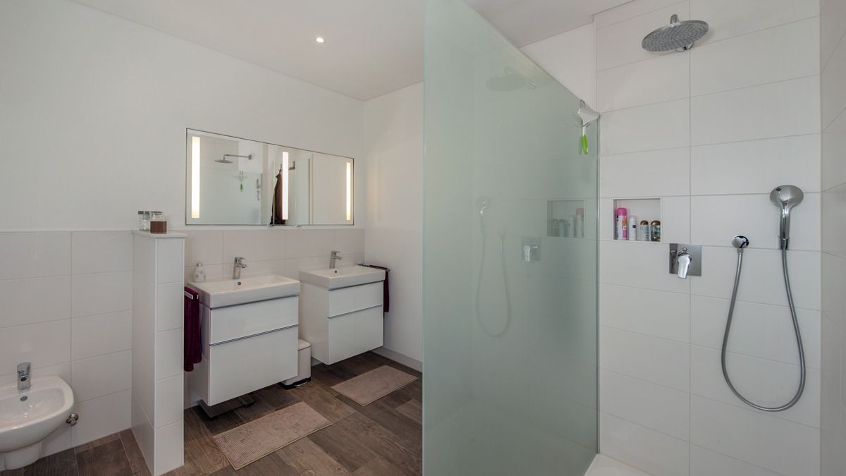 Современная ванная комната с большой душевой комнатой в доме из газобетона.