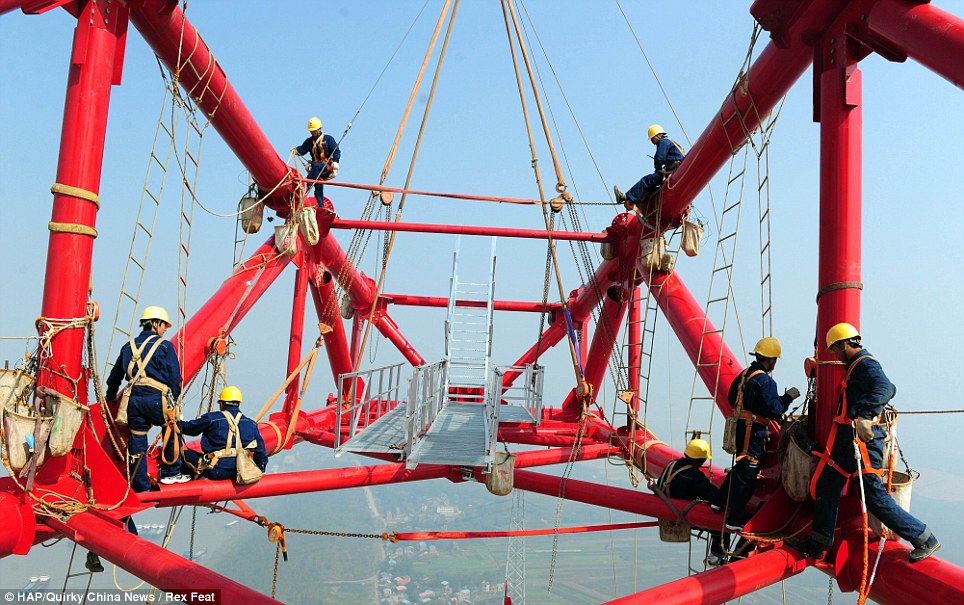 A head for heights: The men work on one of 1,421 electricity pylons that will stretch from Huainan, Anhui province to Shanghai