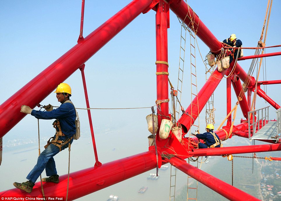 Terrifying: The men all wear safety harnesses but go up and down the pylon on flimsy rope ladders