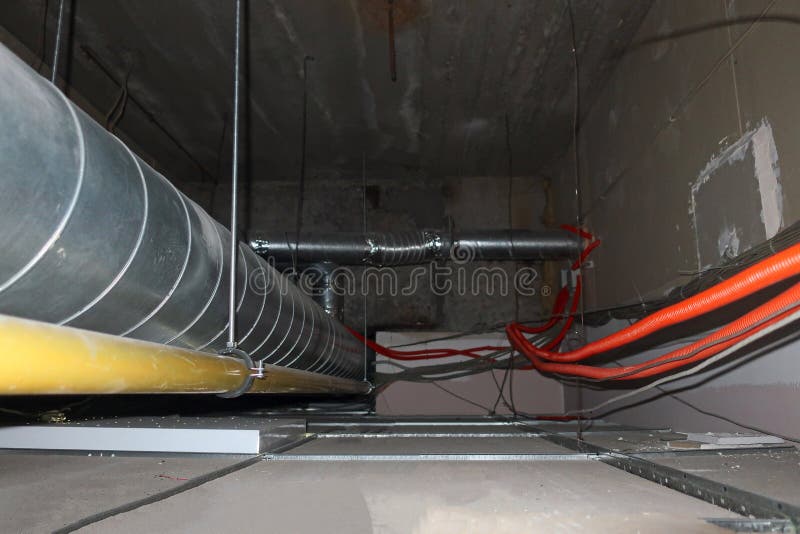 Communications, over a false ceiling. Metal and corrugated pipes and communications, in the space above the false ceiling stock images