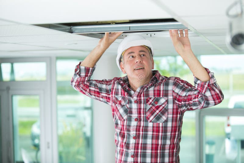 Man install suspended ceiling in house. Man royalty free stock images