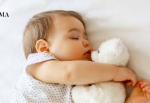 маленькая девочка спит со своей игрушкой